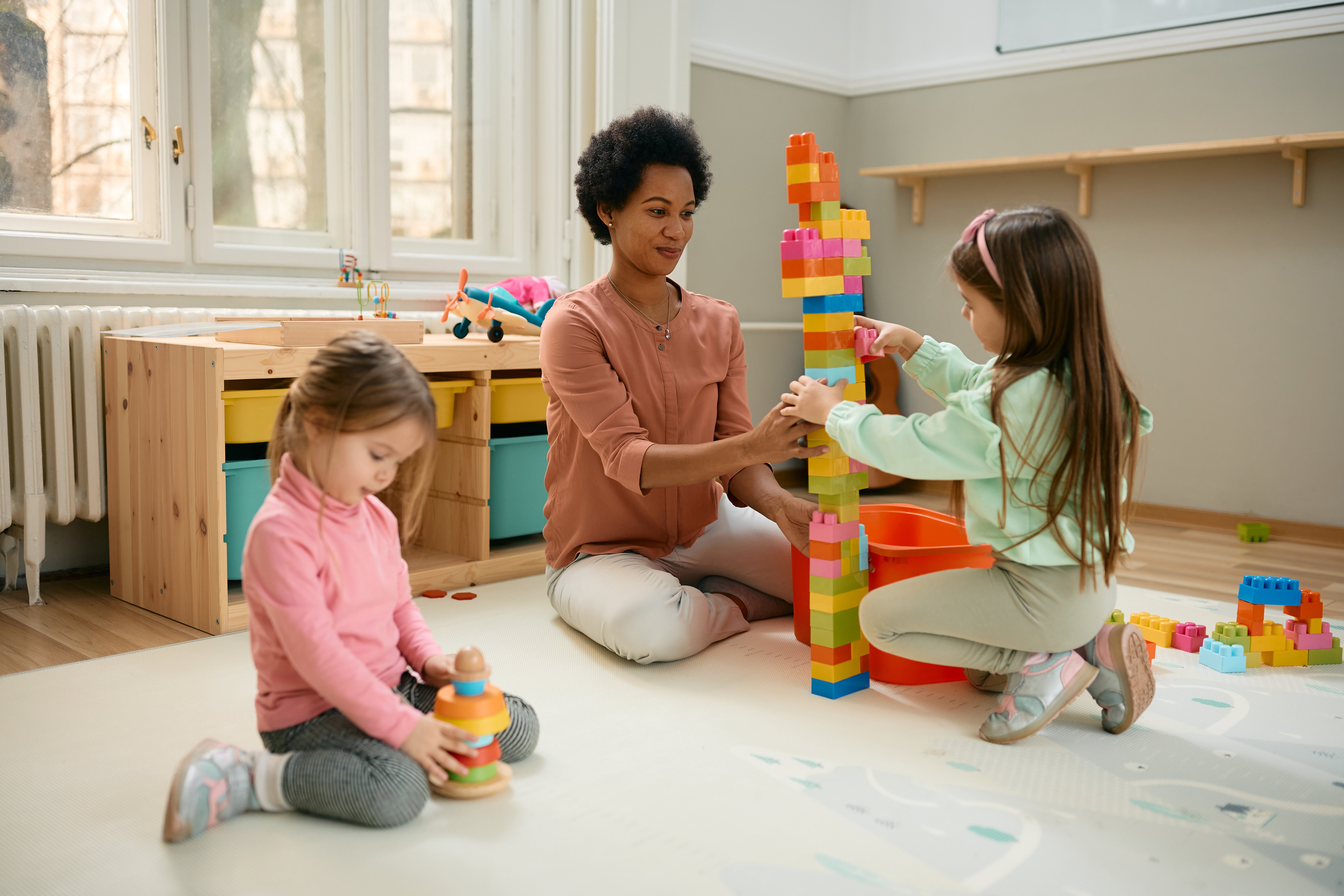 Early learning classroom with smiling teacher and children
